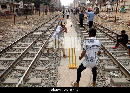 February 17, 2023, Dhaka, Dhaka, Bangladesh: Due to lack of adequate playground in Dhaka, boys are playing cricket between two railway lines. (Credit Image: © Syed Mahabubul Kader/ZUMA Press Wire) EDITORIAL USAGE ONLY! Not for Commercial USAGE! Stock Photo