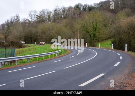 Road with white markings and a turn in the countryside in spring or autumn. Stock Photo