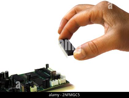 Fingers placing chip. Hand holding integrated circuit on isloted white background. Stock Photo