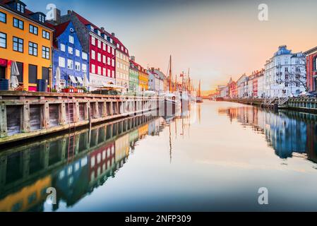 Charm of Copenhagen, Denmark at Nyhavn. Iconic canal, colorful sunrise, and breathtaking water reflections. Stock Photo