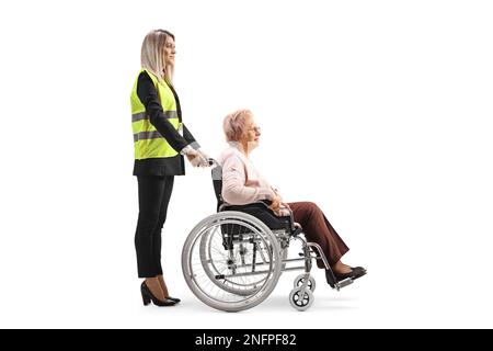 Special assitance worker standing behind a senior woman in a wheelchair isolated on white background Stock Photo