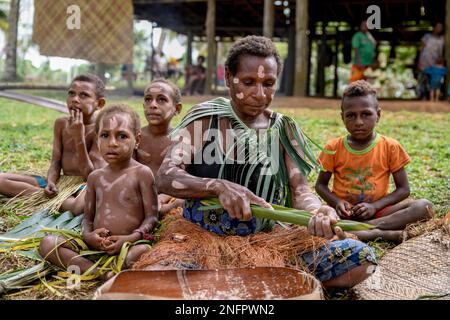 Local woman preparing banana leaves with roasted marrow of the Sago palm, village Pangoa, island Pangoa, Lake Murray, Western Province, Papua New Stock Photo