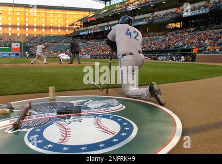 Toronto Blue Jays Frank Thomas kneels in the on deck circle and Vernon  Wells at bat both wear jersey number 42 in honor of Jackie Robinson in the  first inning of a