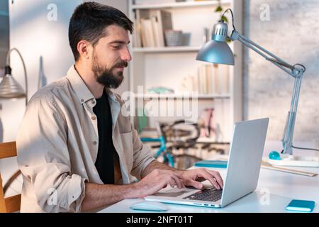Young man student using laptop computer at home studying online.  Stock Photo