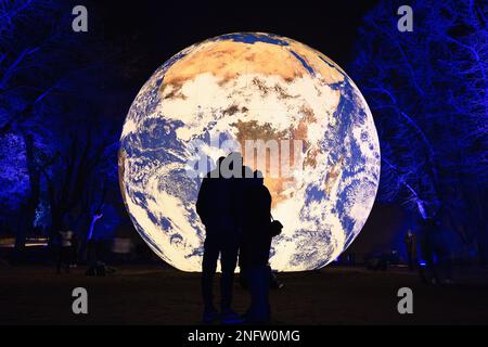 Brescia - Italia. February 15, 2023: Light is Life, (Festa delle Luci A2A), couple clinging to each other in the background of “Floating Earth” by Luk Stock Photo