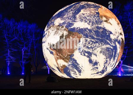 Brescia - Italia. February 15, 2023: Light is Life, (Festa delle Luci A2A), Atlantic Ocean on blue-lit “Floating Earth” by Luke Jerram among blue-illu Stock Photo