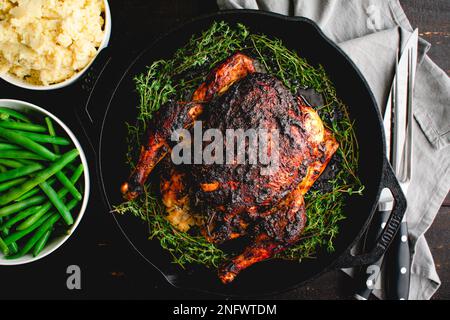 Apple Butter Roasted Chicken Served with Vegetable Side Dishes: Roast chicken in a cast iron pan with mashed potatoes and green beans Stock Photo