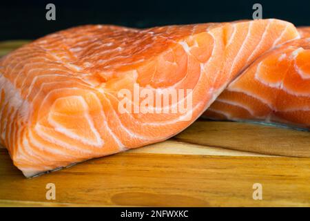 Closeup View of Two Raw Salmon Fillets: Two uncooked salmon fillets stacked on eachother Stock Photo