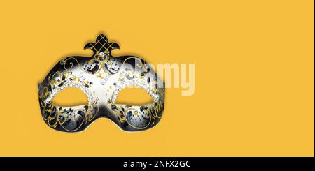 Carnival background with Venetian mask isolated on yellow background. Stock Photo