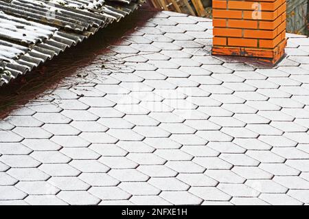 The border of two roofs with different coatings covered with fresh snow. Selective focus Stock Photo