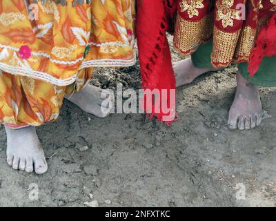 Curious Afghan girls stand barefoot following foreign journalists at