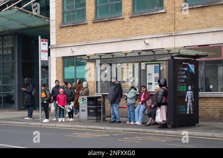Slough, Berkshire, UK. 17th February, 2023. People queue a bus stop to leave Slough. Following a two month fall in  retail sales, it has been reported today that retail sales rose in January 2023, however, there was an overall fall in retail sales volumes fo 5.7% in the three months up to last month. Credit: Maureen McLean/Alamy Live News Stock Photo