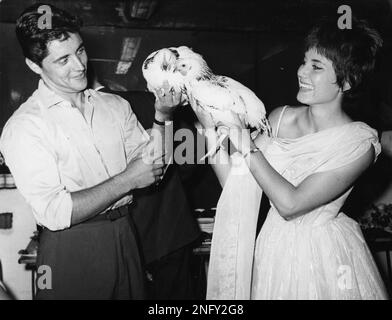 French singer Sacha Distel left hands a chicken to French starlet