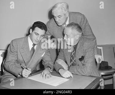 Charley Trippi, left, Georgia football star, signs his $100,000 with Chicago  Cardinals at Chicago, Jan. 17, 1947. Contract covers 4 years. Coach Jimmy  Conzelman is in center and at right is Owner