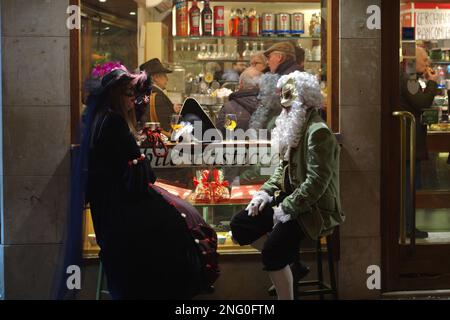 Venice, Italy. 17 Feb 2023. A couple in costume for Carnevale di Venezia sits at a restaurant. Credit: Philip Yabut/Alamy Live News Stock Photo