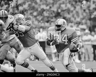 Dallas Cowboys' safety Randy Hughes (42) wrestles with Houston Oilers' star  running back Earl Campbell (34) in Saturday night, Aug. 24, 1980 exhibition  game at Texas Stadium. Campbell picked up a first down on the play before  being stopped by Hughes