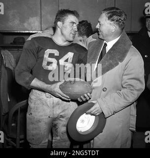 Earl Curly Lambeau, left, the new head coach of the Chicago Cardinals  Football Club, hands a pen to Cecil Isbell, right, to sign as his new  backfield coach in Chicago, Ill., Feb.