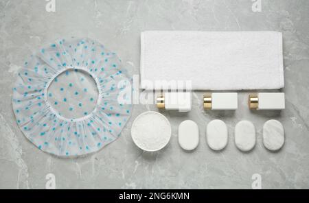 Flat lay composition with shower cap and toiletries on white background ...