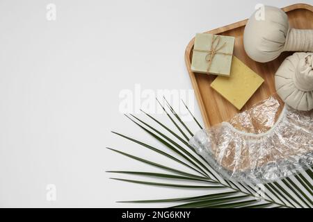 Flat lay composition with shower cap and toiletries on grey marble ...