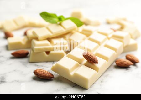 Delicious white chocolate with almonds on marble table, closeup Stock Photo