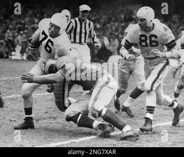 Marion Motley (76), Cleveland fullback, picked up 12 yards and a first down  in the fourth period before he was tackled by Paul Younger, Los Angeles  halfback at Cleveland on Dec. 24