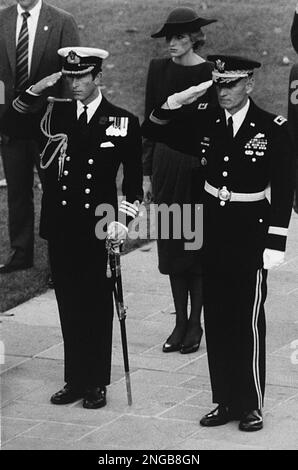 Prince Charles, left, dressed in his ceremonial Royal navy uniform, and Maj. Gen. John Ballantyne, commander of the military district of Washington, salute at the Tomb of the Unknown as and Princess Diana stands at attention behind, during a ceremony at Arlington National Cemetery, Monday, Nov. 11, 1985. (AP Photo/John Duricka)