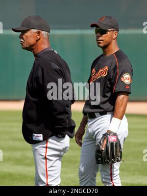 San Francisco Giants' new right fielder Moises Alou, left, listens