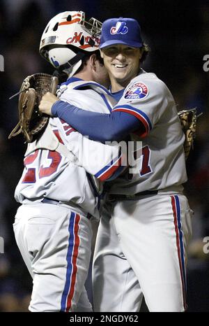 Montreal Expos starting pitcher Scott Downs, left, wipes his forehead as is  teammatesTony Batista, Maicer Izturis and Alex Gonzalez return to play  after the Atlanta Braves scores two runs during third inning