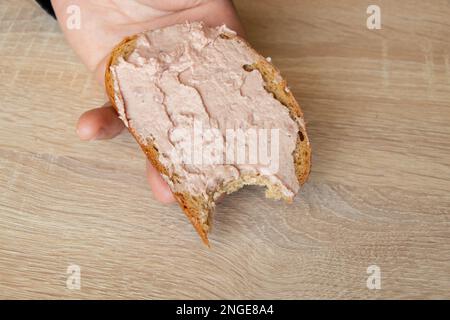 a man s hand holds a sandwich with a paste Stock Photo