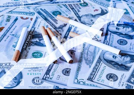 Concept of smoking cost. Cigaretes on a dollars background. Stock Photo