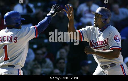 Montreal Expos' Vladimir Guerrero, right, swings for a homerun to  left-center in the sixth inning of the second game of a day-night  doubleheader against Cincinnati Reds at the Hiram Bithorn Stadium in