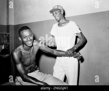 Satchel Paige, the ageless right-handed pitching star, returns to major  league baseball starting for the Browns in St. Louis, on July 19, 1951.  Here he is seen warming up prior to a