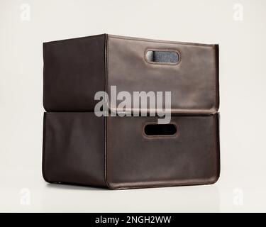 Two storage boxes of brown faux leather with slotted handles Stock Photo