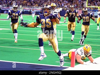 Arizona Cardinals Larry Fitzgerald jumps to catch the football for a  37-yard gain in front of St. Louis Rams Aeneas Williams (35) and Jerametius  Butler (23) for the first play of the