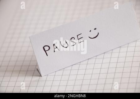 Pause and smiley handwritten on a piece of paper and left Stock Photo