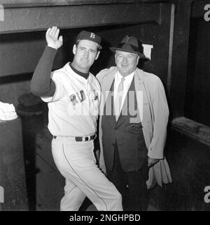 Ted Williams (9), Boston Red Sox outfielder, waves as he confers with  manager Joe Cronin, president of the American League, in the dugout at  Fenway Park before the game against Baltimore Orioles in Boston, Ma. on  Sept. 28, 1960. The retiring 42-year