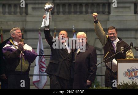 As Baltimore Ravens David Modell, president and CEO holds up the Super Bowl  trophy, members of the Baltimore Ravens Marching Band reach out to touch it  at the end of the parade