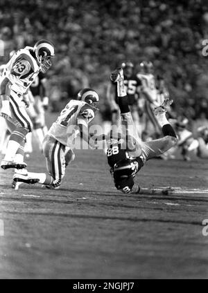 The Pittsburgh Steelers' receiver Lynn Swann (88) goes down to the turf  after making a catch as Los Angeles Rams' defender Pat Thomas (27) comes in  during a Super Bowl XIV fourth