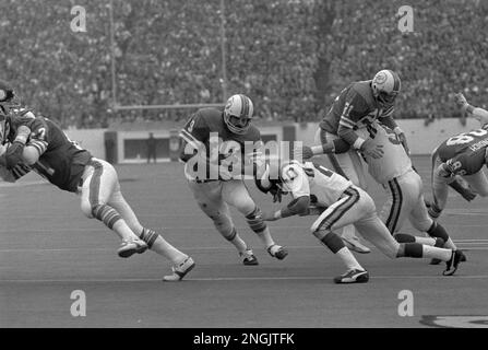 Miami Dolphin back Jim Kiick (21) seems totally unaware that he is about to  be trounced by New York Jets John Elliott (80) during action in their AFL  game Sunday afternoon Dec.