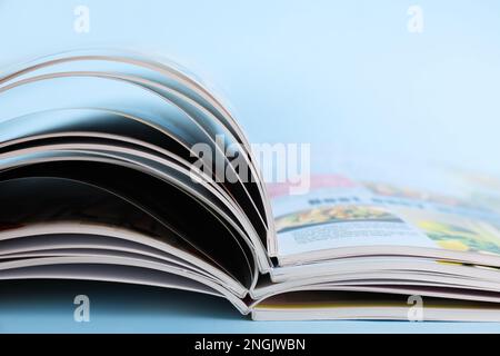 Stack of magazines on light blue background, closeup Stock Photo