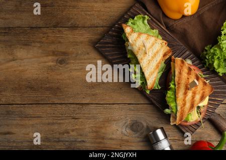 Wooden board with tasty sandwiches on table, flat lay. Space for text Stock Photo