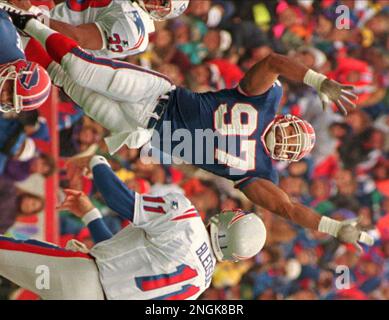 Buffalo Bills linebacker Cornelius Bennett, right, helps Houston Oilers  quarterback Warren Moon to his feet after sacking him in the third quarter  of their AFC playoff game at Rich Stadium in Orchard