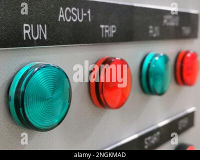 Close up view a row of led pilot lamps with tags mounted on electrical cabinet door. Stock Photo