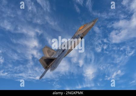 F-22 Raptor Armed Fighter Jet on a combat mission. F22 Raptor jet fighter warplane flying in front of the moon armed with sidewinders and missiles. Stock Photo