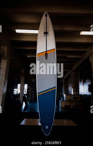 Colorful inflatable stand-up paddle board SUP by the wall. Surfing and ...