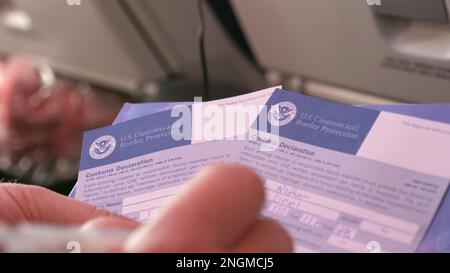 Man filling out US customs declaration forms before entering the USA Stock Photo