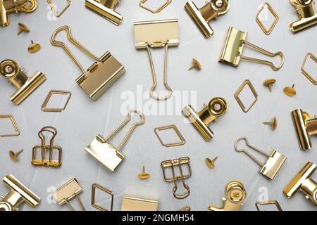 Flat lay composition with golden binder clips on light grey background Stock Photo