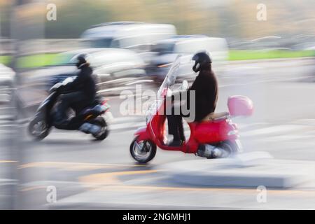 picture with camera made motion blur effect of Scooter riders in heavy city traffic Stock Photo