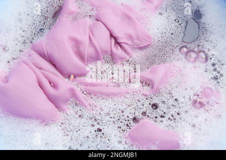 Color clothing in suds, top view. Hand washing laundry Stock Photo