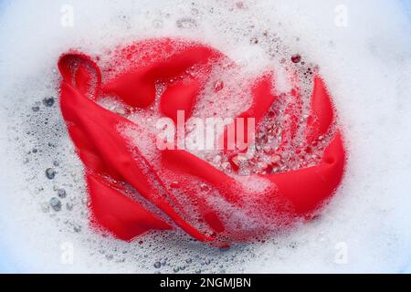 Color clothing in suds, top view. Hand washing laundry Stock Photo